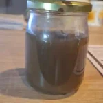 Prélèvement du fond de cuve remué avec particules en suspension révélant l’encrassement